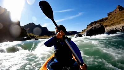 Man Kayaking Through Whitewater Rapids In A Canyon