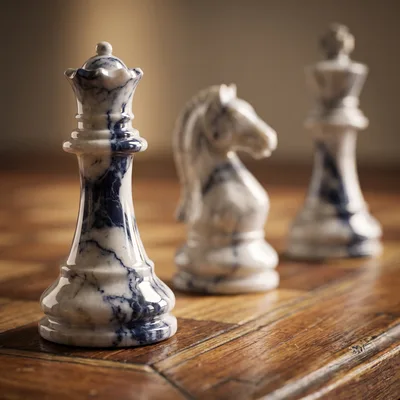 Marble Chess Pieces Arranged On A Wooden Board