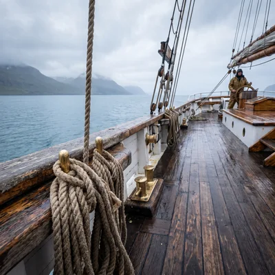Sailor Steering Traditional Wooden Sailing Ship
