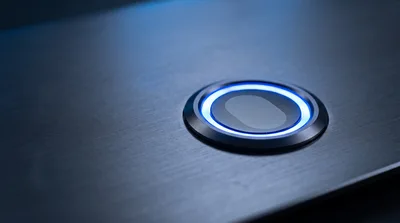 Illuminated Power Button On Brushed Metal Surface