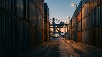 Shipping Container Terminal At Dusk With Port Crane