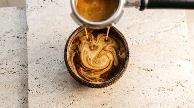 Espresso Pouring Into A Coconut Shell Bowl