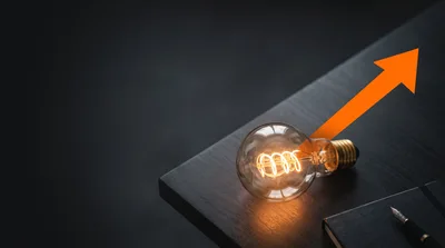 Glowing Light Bulb With Upward Trending Orange Arrow