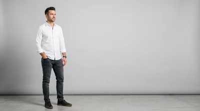 Man Standing In White Shirt And Jeans