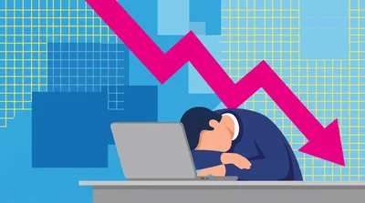 Stressed Businessman Resting Head On Laptop With Declining Graph
