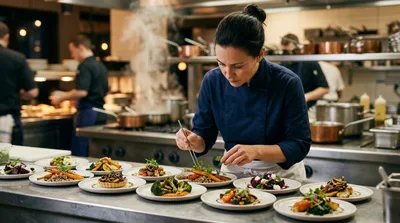 Professional Chef Plating Gourmet Dishes In Restaurant Kitchen