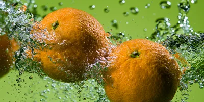 Two Fresh Oranges Splashing Into Water