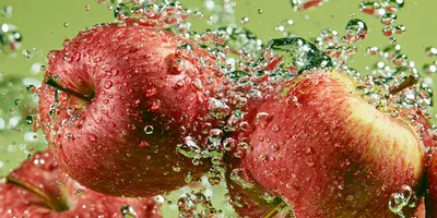 Red Apples Splashing Into Water With Bubbles