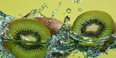 Fresh Kiwi Fruit Slices Splashing In Clear Water