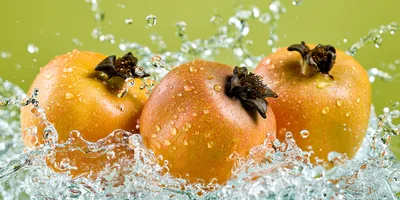 Three Fresh Pomegranates Splashing In Clear Water