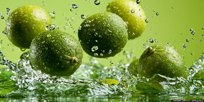 Fresh Green Limes Splashing Into Water