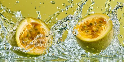Two Halves Of Passion Fruit Splashing In Water