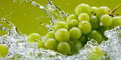 Fresh Green Grapes Splashing In Clear Water
