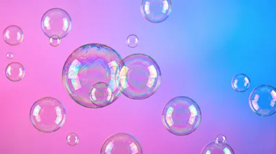 Floating Iridescent Soap Bubbles Against Gradient Background