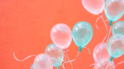Floating Pastel Balloons Against A Vibrant Orange Background