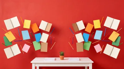 Floating Stationery and Notebooks Above White Desk