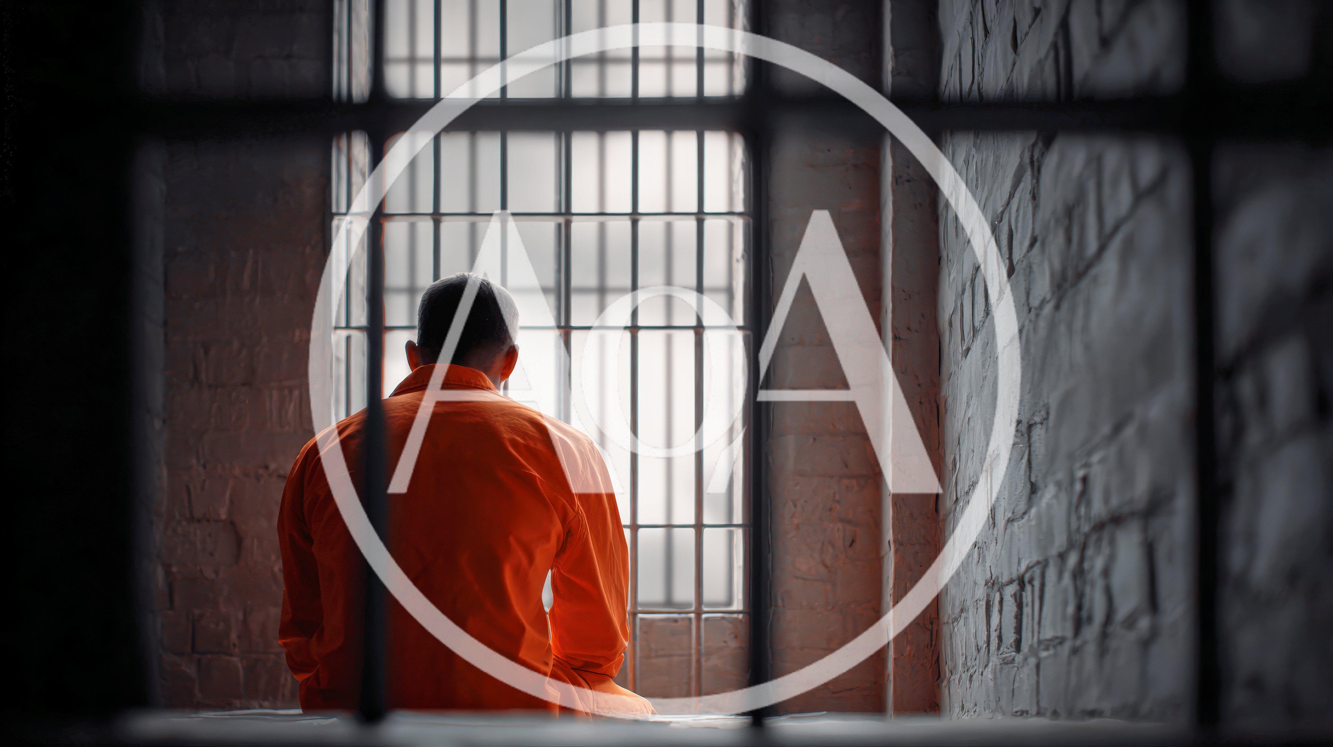 Prisoner In Orange Jumpsuit Sitting In Jail Cell
