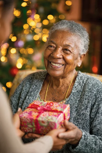 Elderly Woman Receiving A Christmas Gift From A Relative