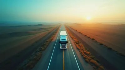Semi Truck Driving On Desert Highway At Sunrise