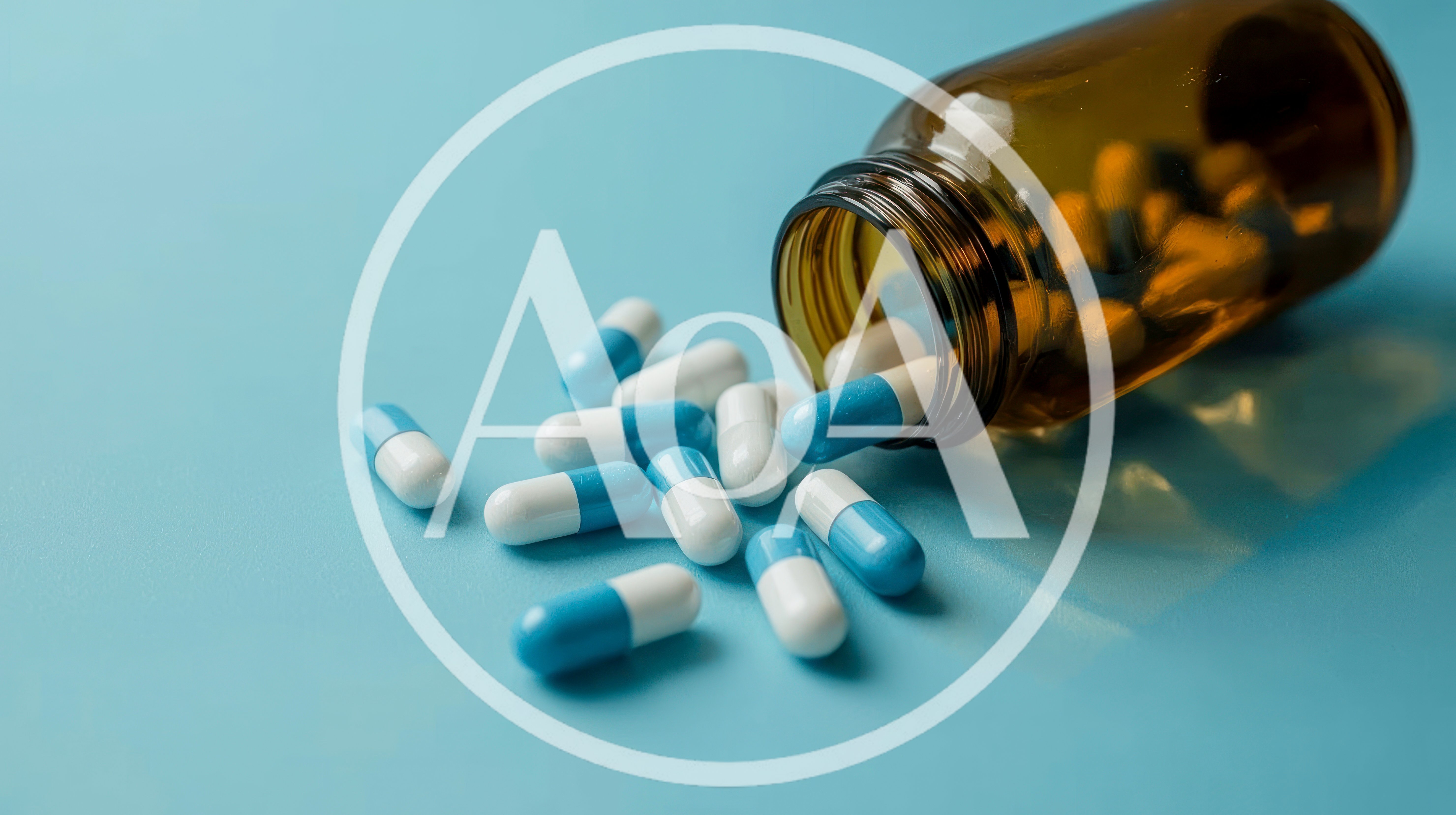 Blue and White Capsules Spilling From Amber Glass Bottle