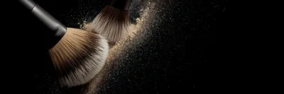 Two Makeup Brushes With Loose Powder On Black Background