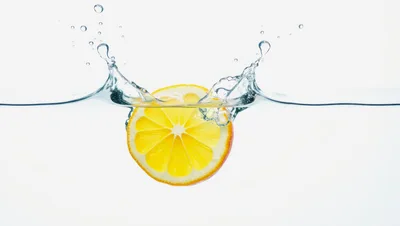 Lemon Slice Dropping Into Clear Water With Splash