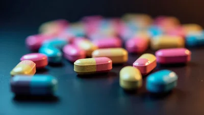Colorful Pharmaceutical Pills Scattered on Dark Surface