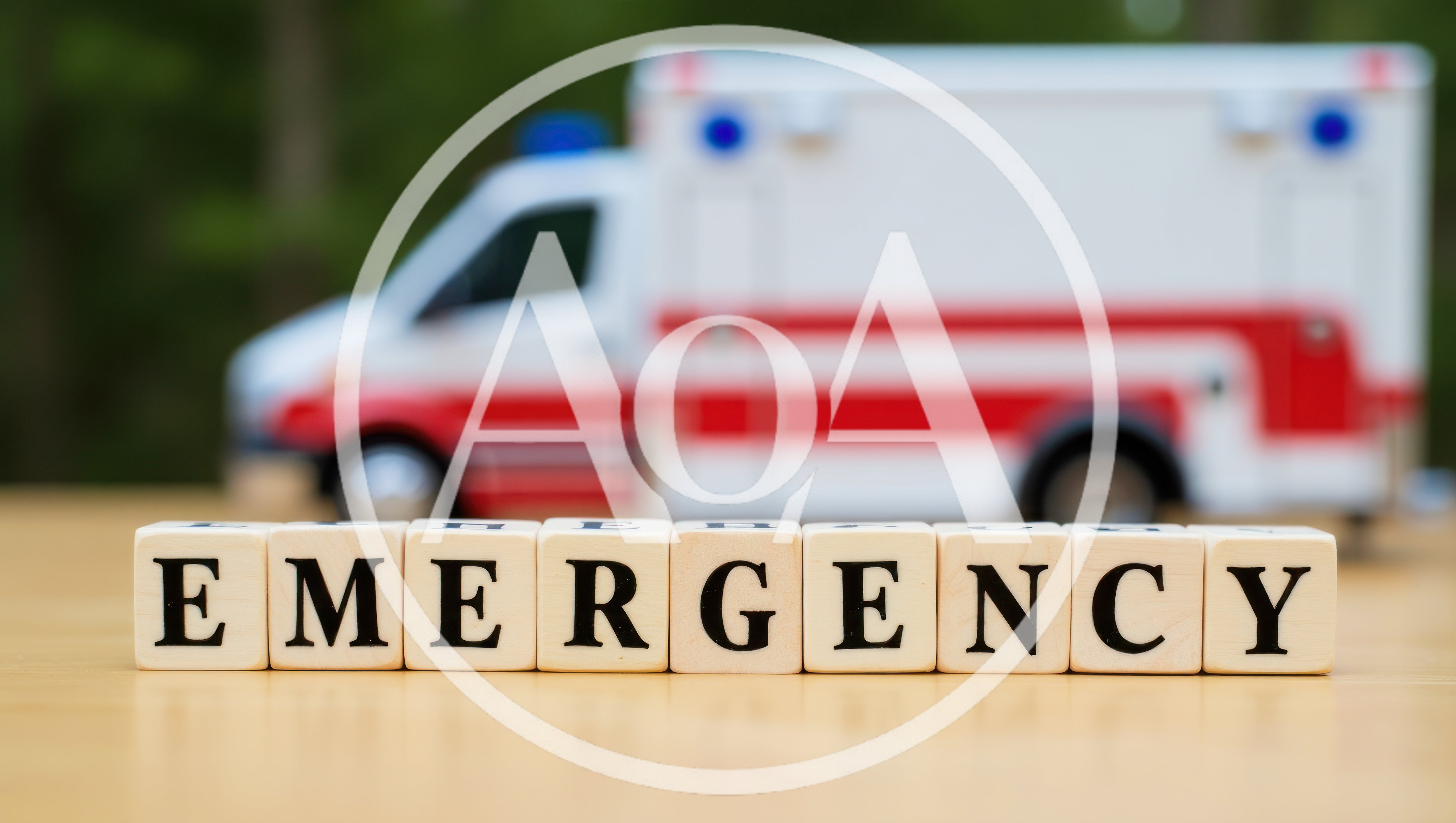 Wooden Blocks Spelling Emergency With Ambulance In Background