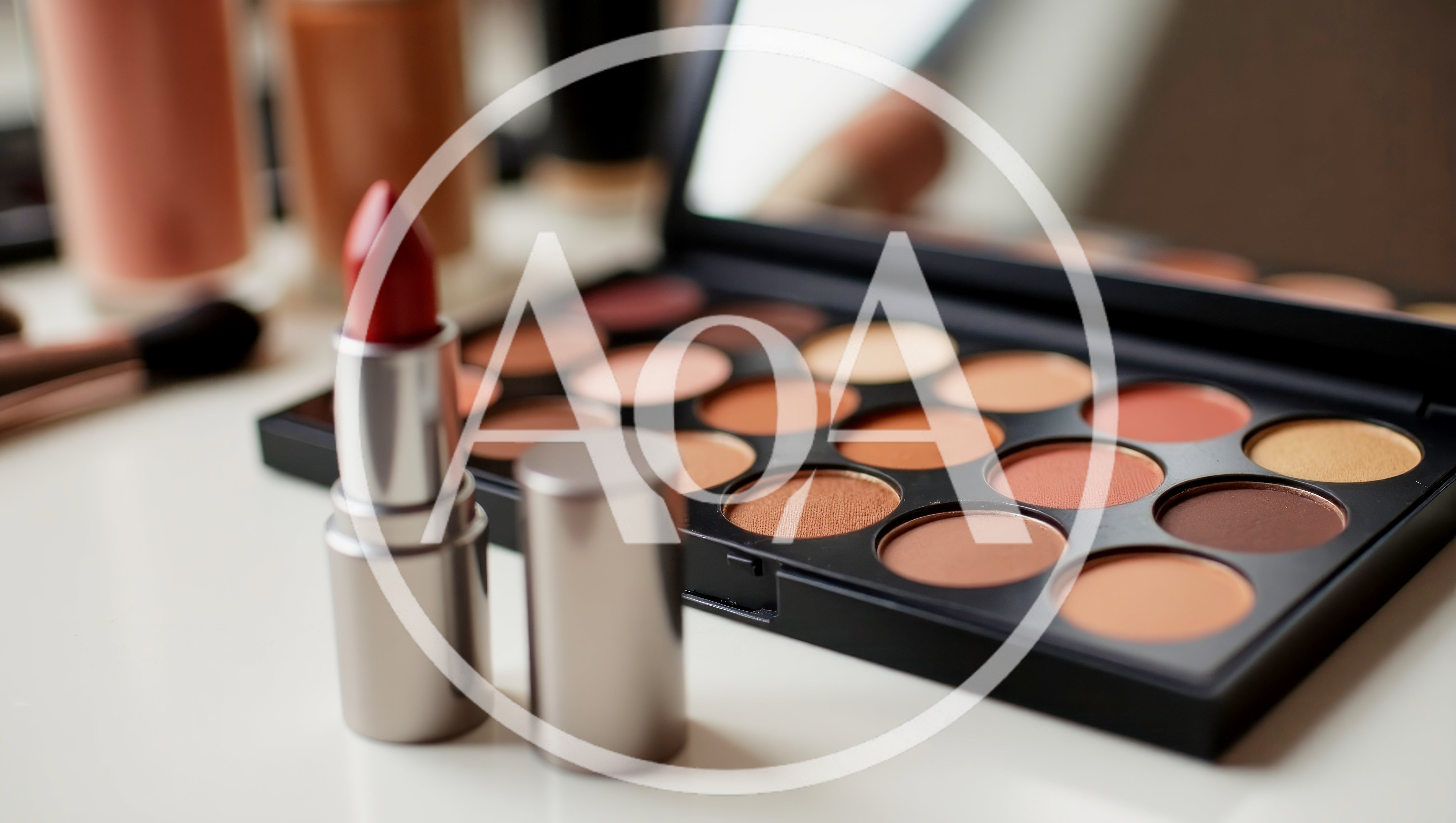 Makeup Palette and Red Lipstick on White Surface