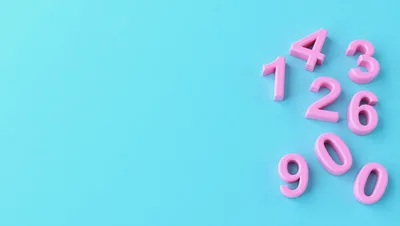 Pink Plastic Numbers Scattered on Light Blue Background