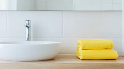 Modern Bathroom Sink With Yellow Towels On Wooden Counter