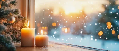 Two Lit Candles Beside A Snowy Christmas Tree