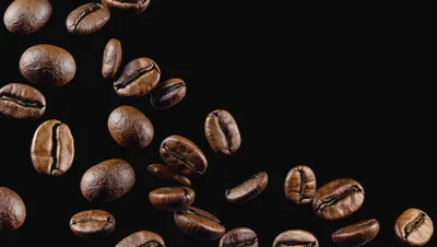 Roasted Coffee Beans Falling Against Black Background