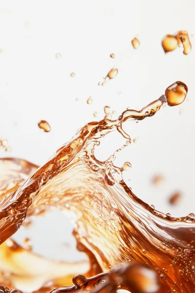 Dynamic Amber Liquid Splash Against White Background