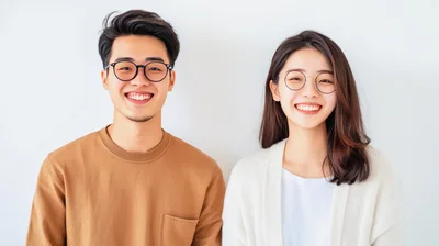 Young Asian Couple Smiling Together Against White Background
