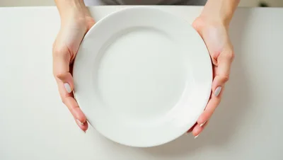 Woman Holding An Empty White Plate