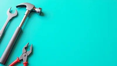 Hammer Wrench and Pliers on Teal Background