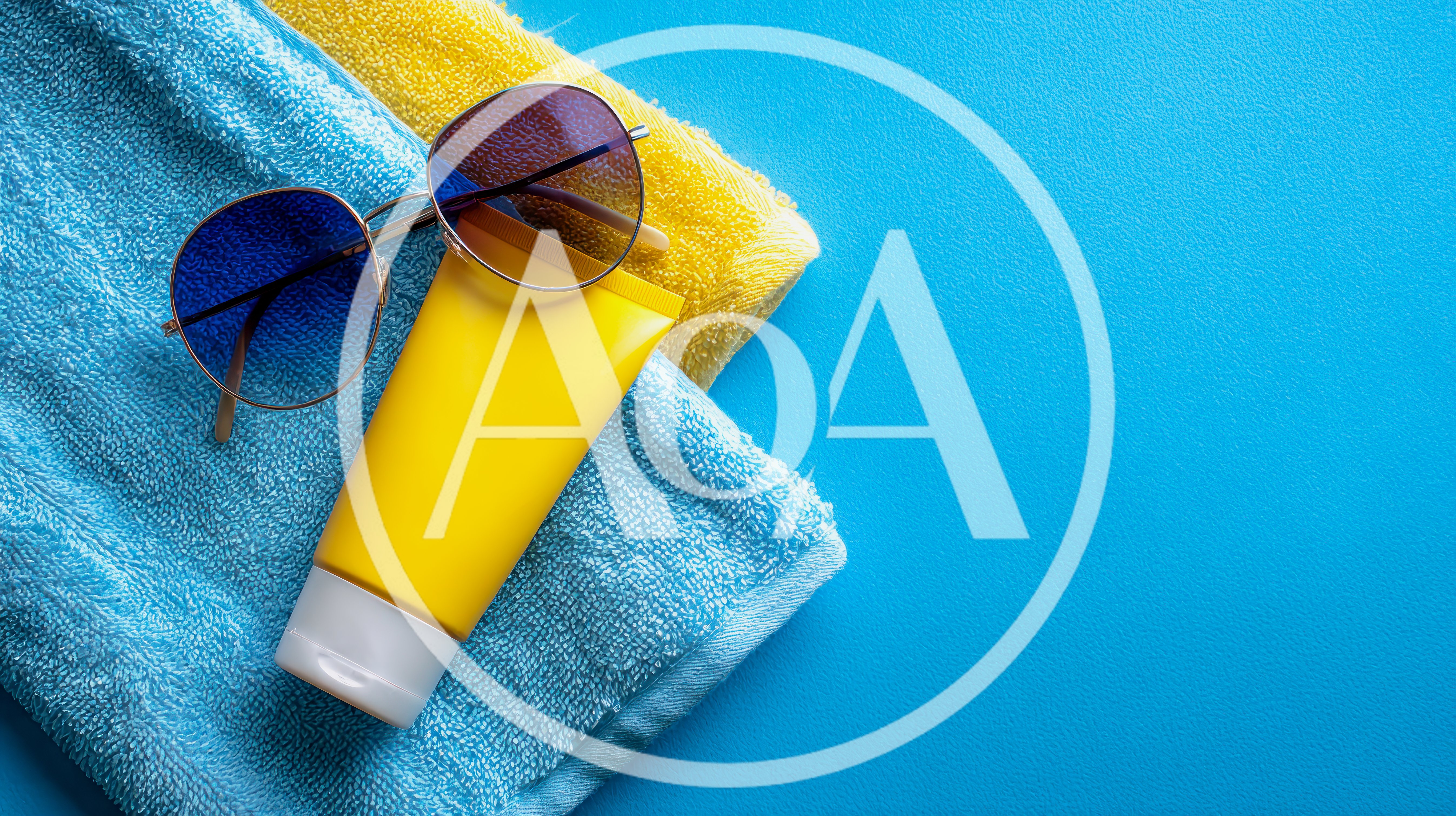 Sunglasses And Sunscreen On Blue And Yellow Towels