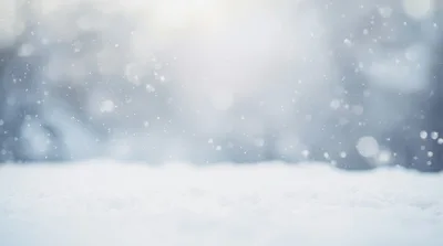 Soft Snow Falling Over A Blurred Winter Forest Background