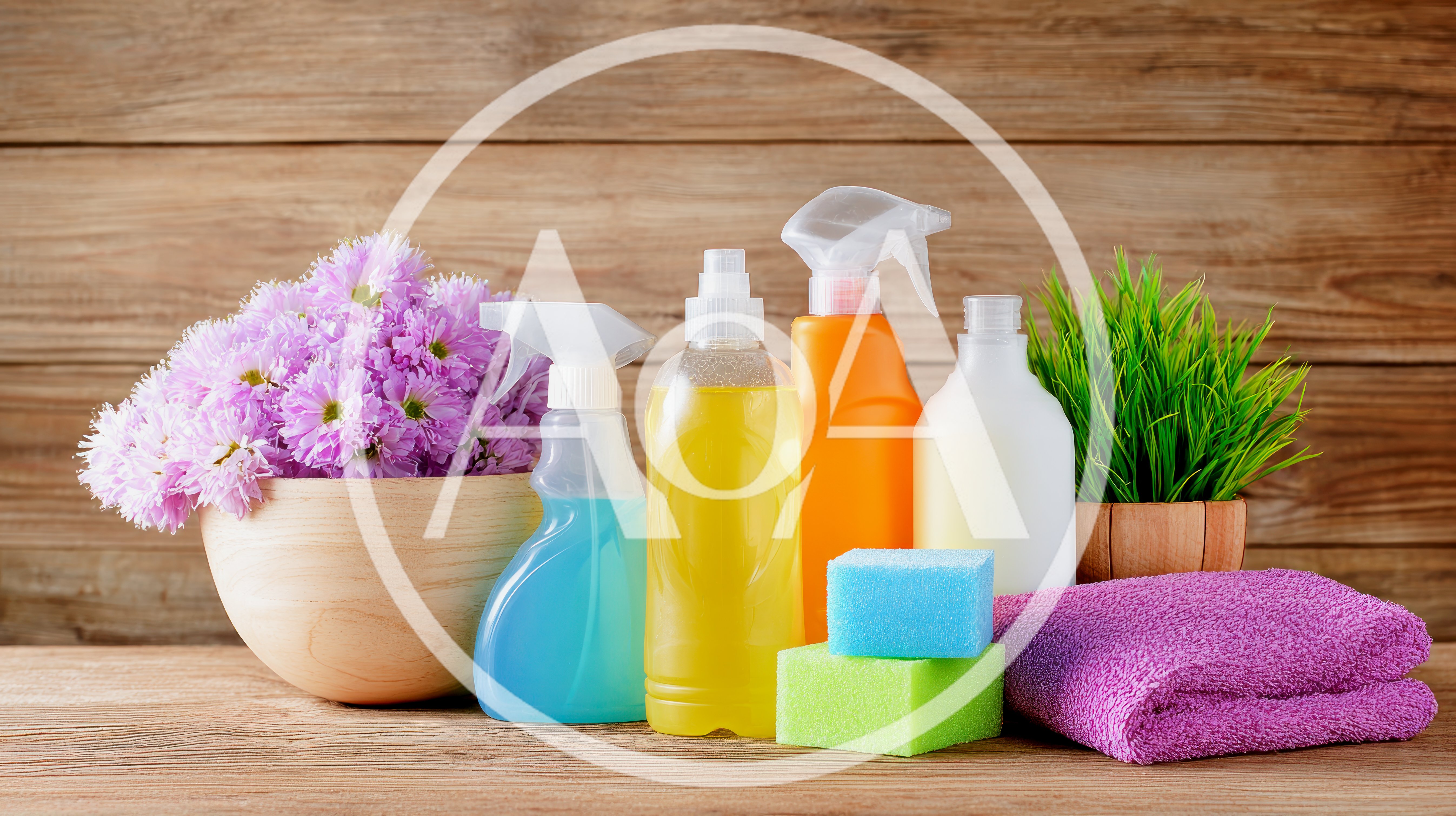 Cleaning Supplies With Flowers And Towel On Wooden Table