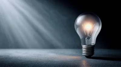 Glowing Light Bulb On A Dark Surface