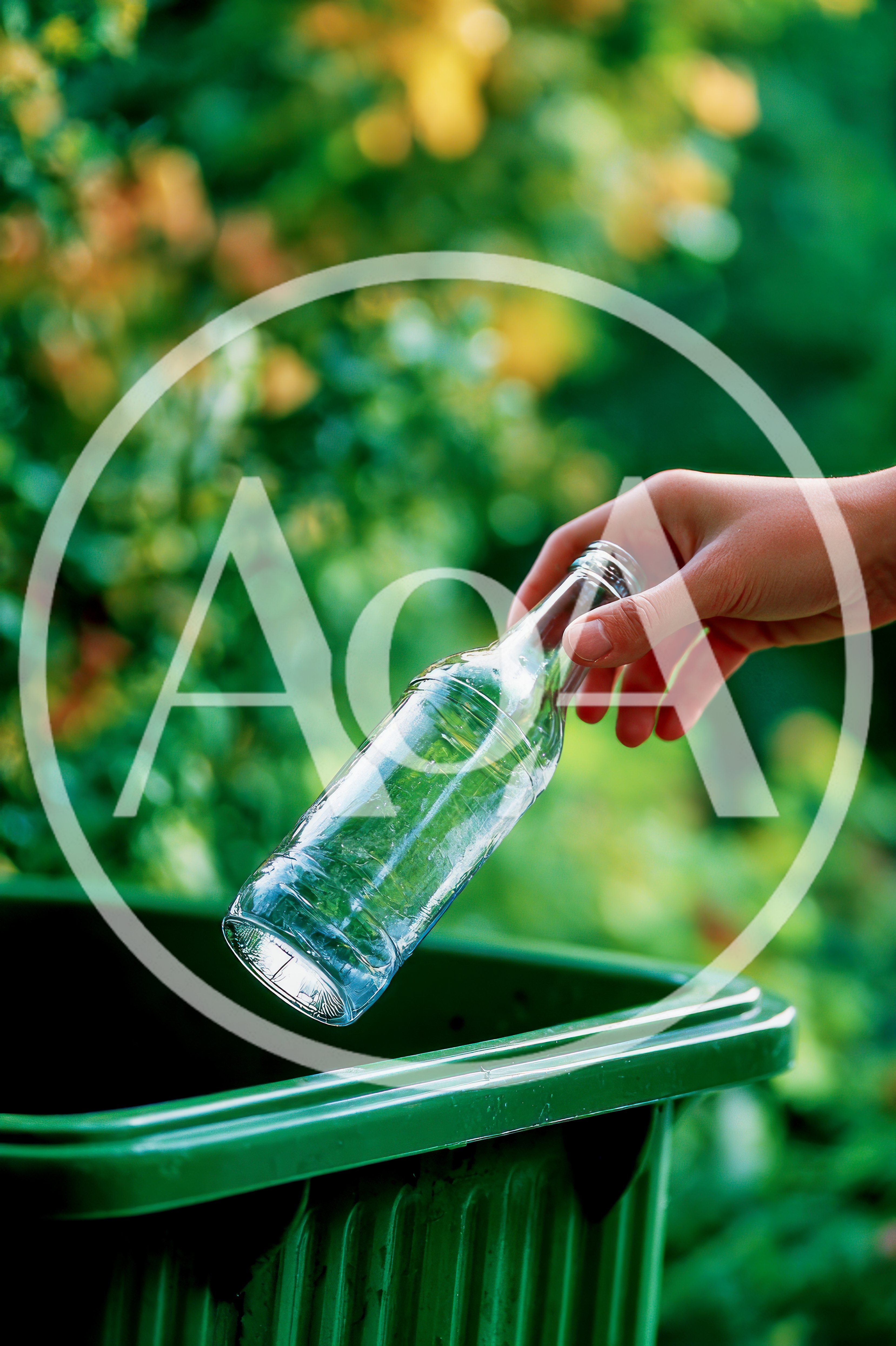 Hand Placing Glass Bottle Into Recycling Bin