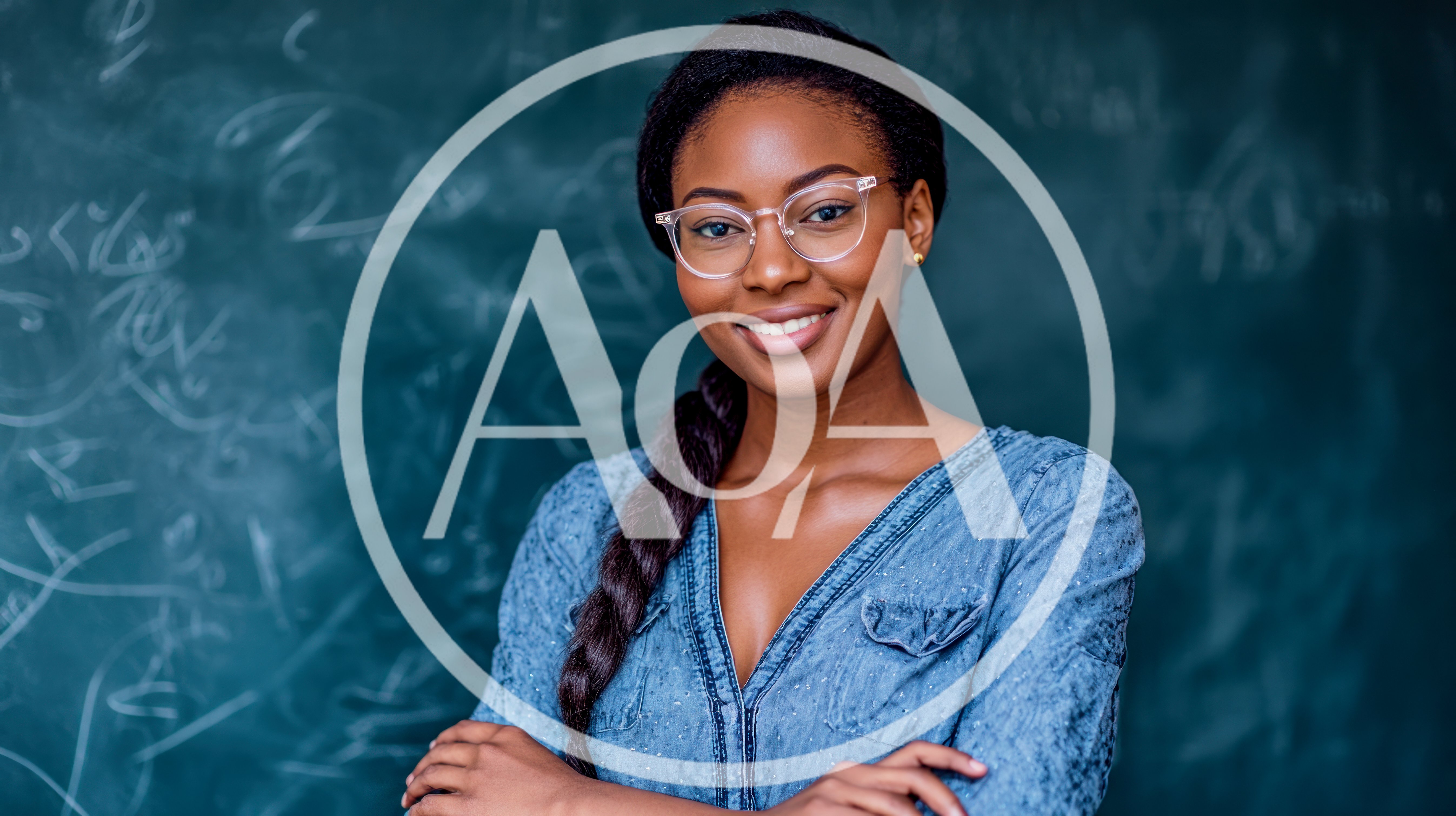 Smiling Female Teacher Standing In Front Of Chalkboard