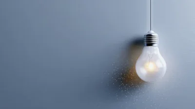 Glowing Light Bulb Hanging Against A Grey Background