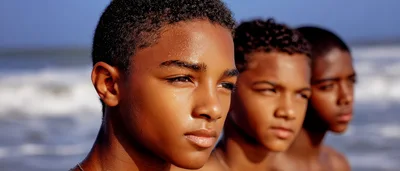 Three Young Boys Standing Together On A Beach