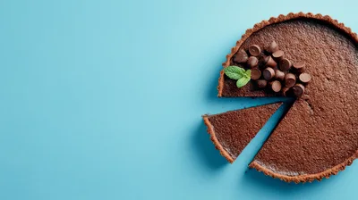 Chocolate Tart With A Slice Removed On Blue Background