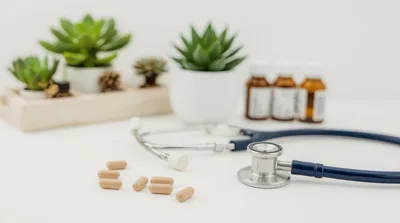 Stethoscope and Medical Capsules on White Desk