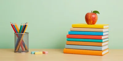Stack of Colorful Books with Apple and Pencils