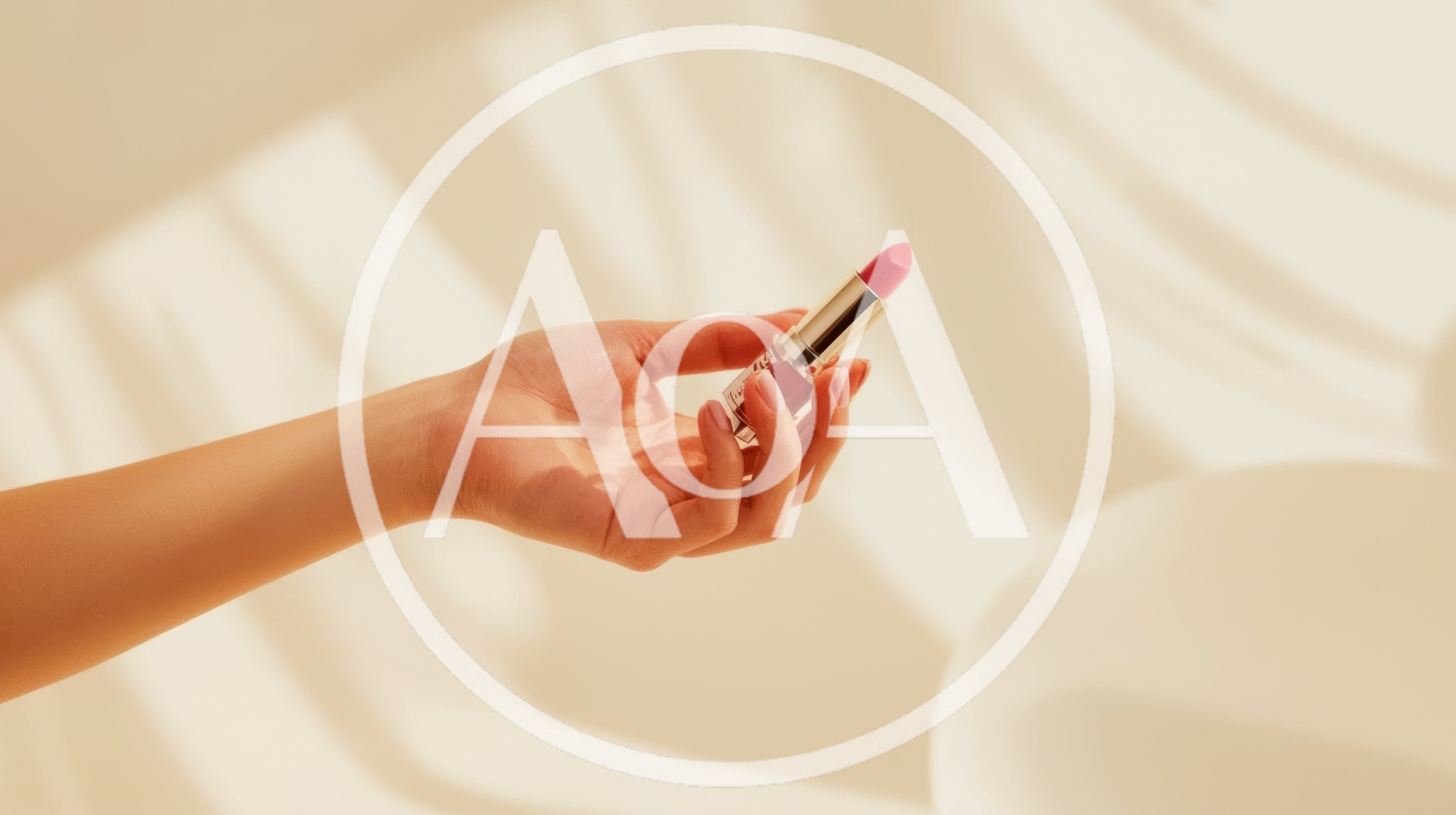 Hand Holding A Lipstick Tube In Soft Sunlight