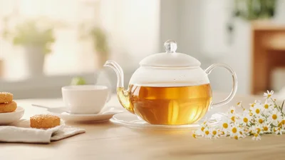 Glass Teapot With Chamomile Tea And Cookies